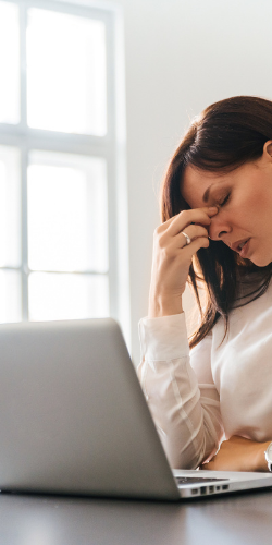 Woman  looking at laptop overwhelmed thinking about designing a website